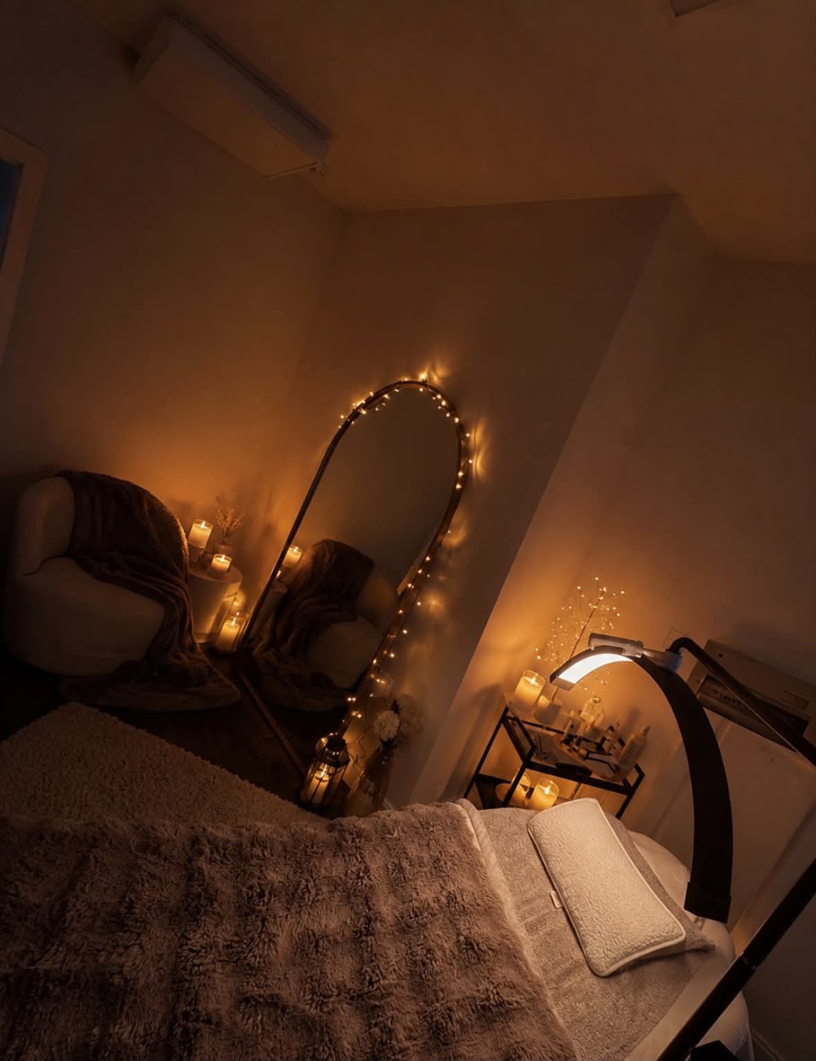 A corner of the treatment room, with the arched mirror and candlelight